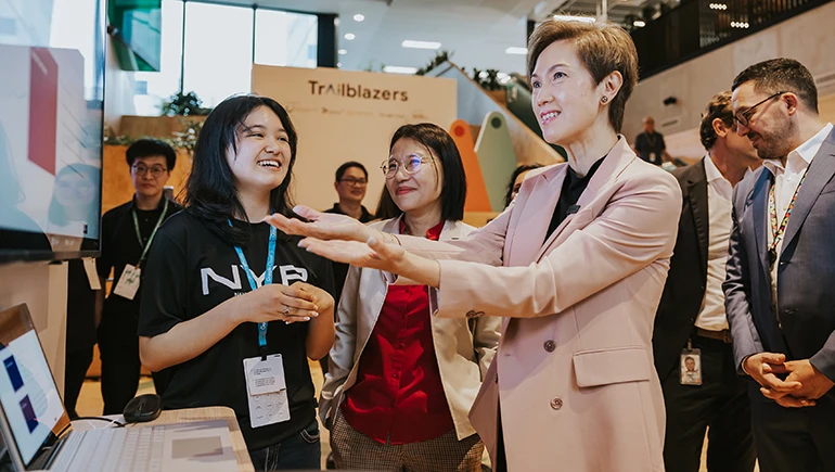 Josephine Teo, Minister for Communications and Information, engages with representatives from Nanyang Polytechnic and their gen AI-powered NYP Course AutoBot solution at the Google Cloud ExploreAI summit.
