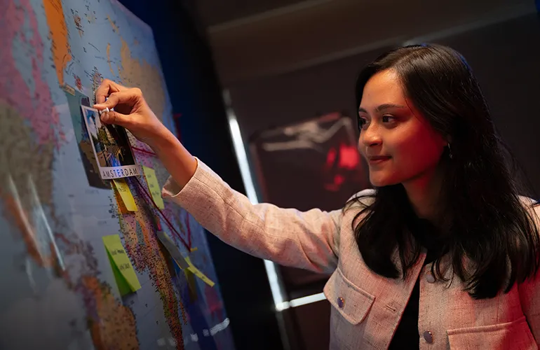 Maisarah pinning her journey around the map.