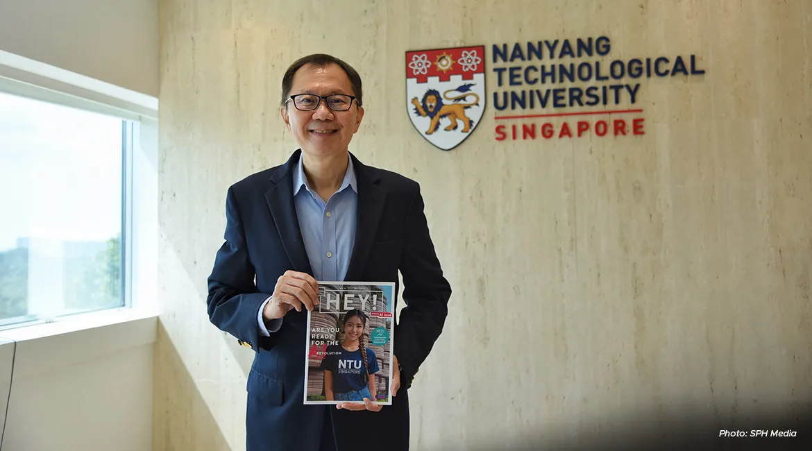 NTU President Ho Teck Hua with the latest issue of campus publication HEY!, a magazine co-created with generative AI technologies.