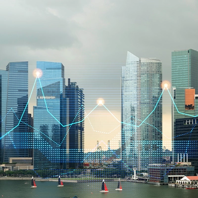 A city skyline featuring modern glass skyscrapers by the waterfront, overlaid with digital data graphics including glowing data points and fluctuating line charts, representing financial or technological growth trends. Sailboats are visible in the water, adding a dynamic element to the urban scene.