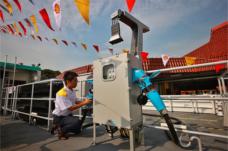 Shell electrical engineer Lim Hong Jin working on the AC slow charger for the electric ferry, with the DC fast charger nearby. Image courtesy of SPH Media.